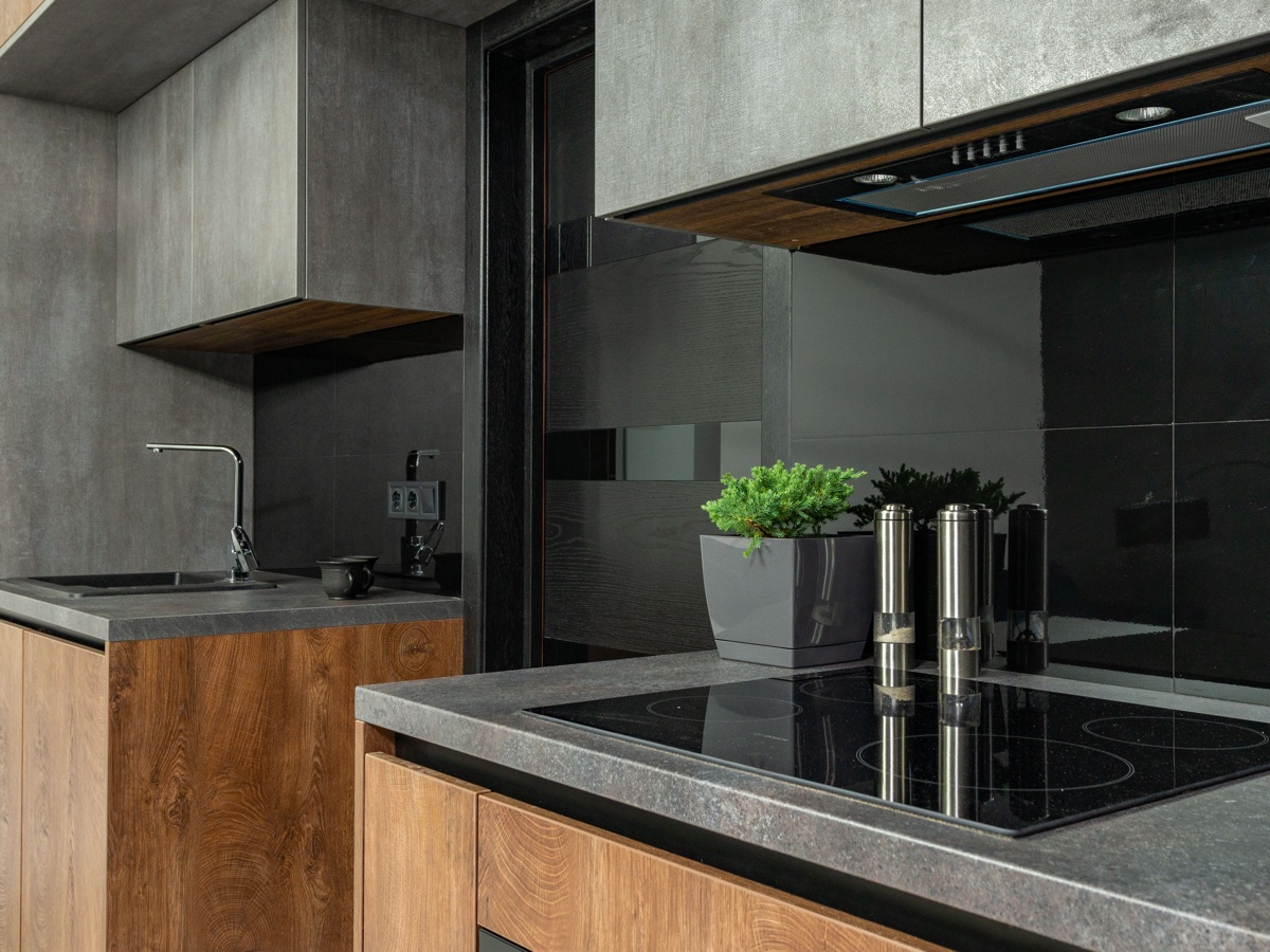 Representative finished kitchen with wood cabinetry, stone worktops and dark splashback